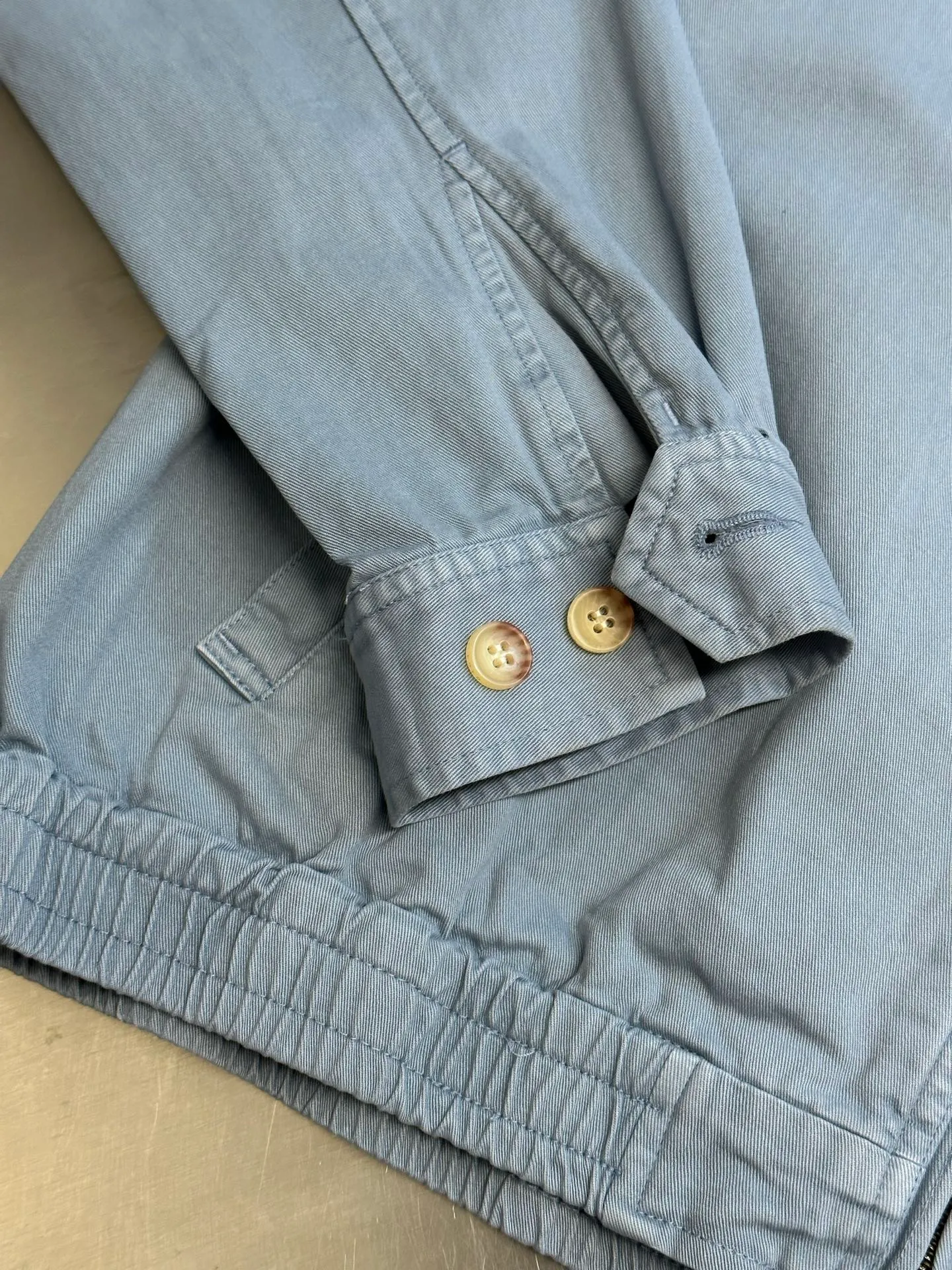 P480 Ralph Lauren embroidered zipper jacket, custom-made cloud velvet blue twill fine cotton, embellished with exquisite white pony logo, fully recognizable. Using imported machine embroidery technology, advanced computer control systems and precision mechanical components are used to achieve the iconic pony embroidery operation with high precision.  The hem is made at one time using a three-needle waist-stretching machine. The machine's special needle position and feeding mechanism are used to sew the elastic band and the fabric together in the same process. The three-needle design is stronger and can evenly distribute pressure to ensure a tight fit between the elastic band and the fabric. Follow the original color series for dyeing and overprinting. Prioritize the original color and fabric material to select special dyes, then heat to the appropriate temperature, perform dip-dyeing, and finally perform color overlay.  size：s m l xl